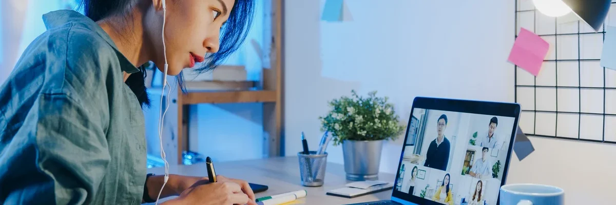 Asian Women at her laptop in a meeting taking notes